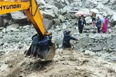 轿车坠湖 两工人用挖掘机接力救人